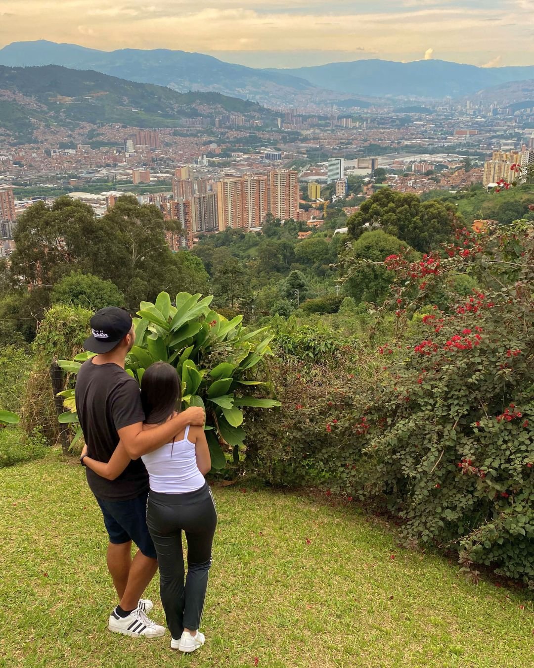 A moment of connection with Medellin – our home away from everywhere Couple looking over Medellin from a scenic mountain viewpoint, surrounded by nature. About Medellin Insider