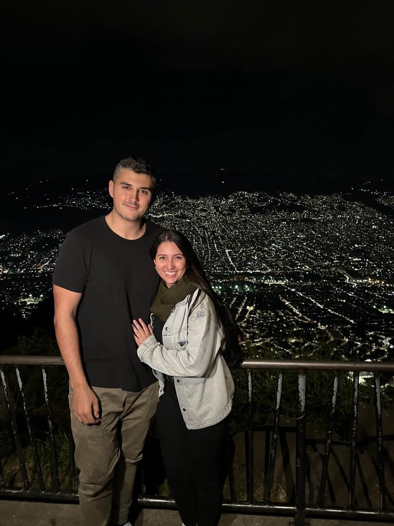 Goran & Tatiana overlooking Medellin at night from a city viewpoint Goran and Tatiana at a nighttime viewpoint overlooking Medellin’s city lights. Colombia Travel Planning.