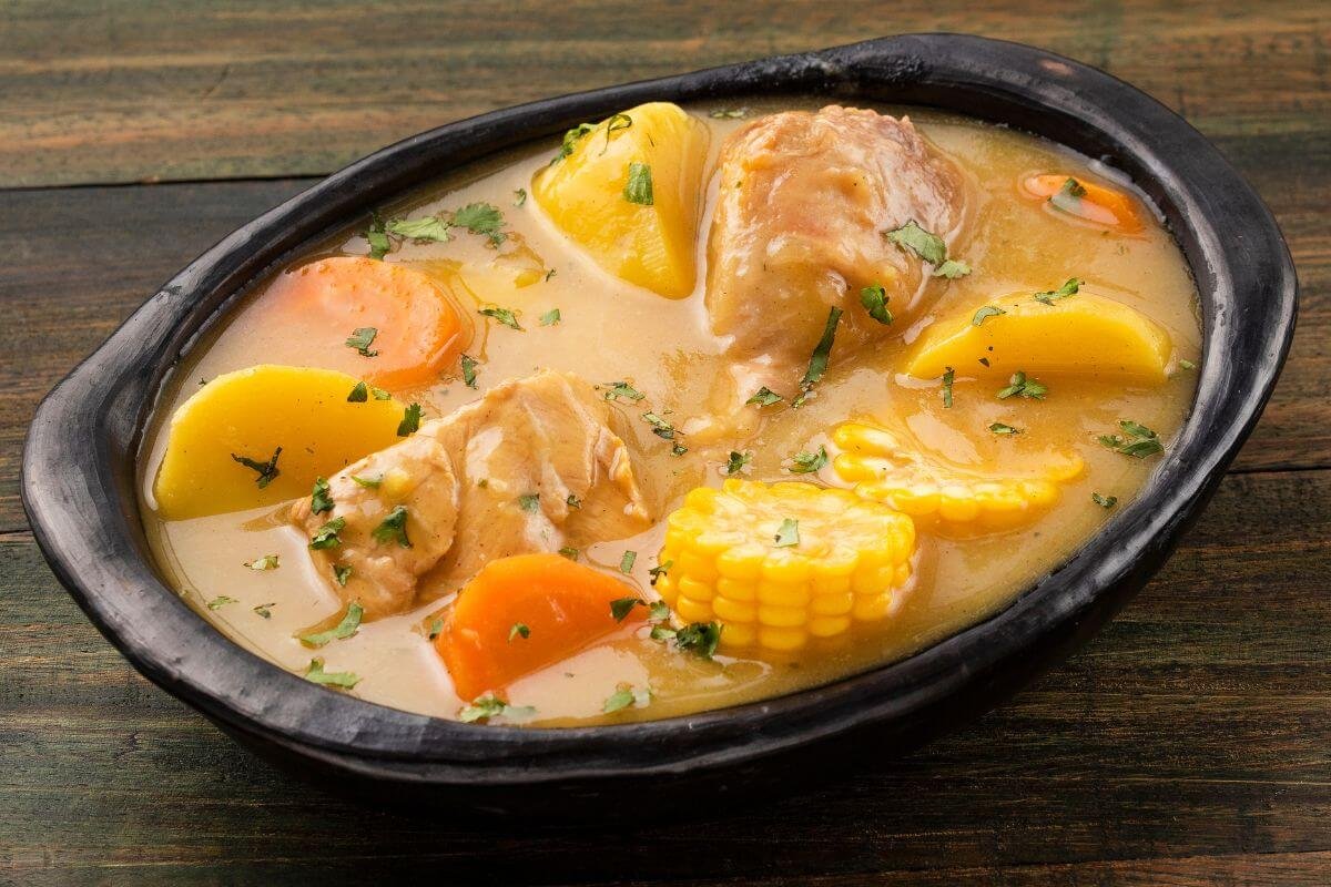 Colombian sancocho soup with chicken, vegetables and corn in a rustic bowl