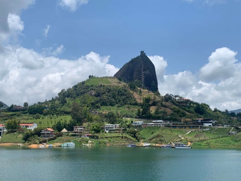 El Peñol rock view from Guatape lake – iconic day trip highlight near Medellin on a sunny day El Peñol rock rising above the lake near Guatape, Colombia, seen from the waterfront