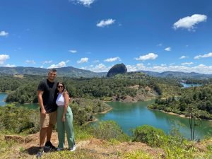 Guatape day trip from Medellin – Scenic viewpoint with El Peñol Couple at a scenic viewpoint during a Guatape day trip from Medellin, with El Peñol rock in the background